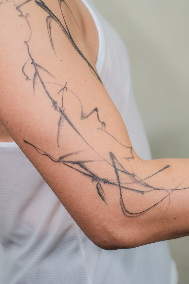 Abstract smoke flow tattoo wrapping around the upper arm by Melbourne tattoo artist Mr Inking Tattoo